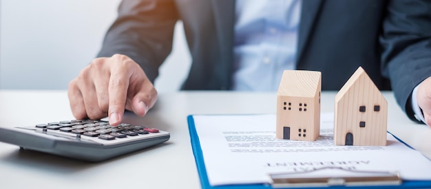 Man using calculator during signing home contract documents Contract agreement real estate buy and sale and insurance concepts