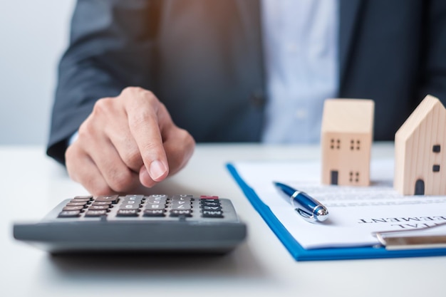 Man using calculator during signing home contract documents Contract agreement real estate buy and sale and insurance concepts