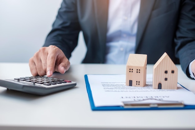 Man using calculator during signing home contract documents Contract agreement real estate buy and sale and insurance concepts