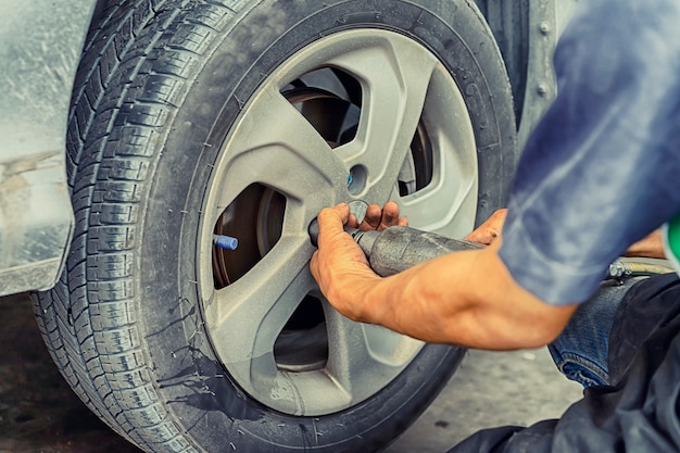 Man using car mechanic Block the wind wheel.     To check your tires and brake for car.Auto mechanic Preparing For the work.