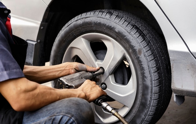 Man using car mechanic Block the wind wheel.     To check your tires and brake for car.Auto mechanic Preparing For the work.