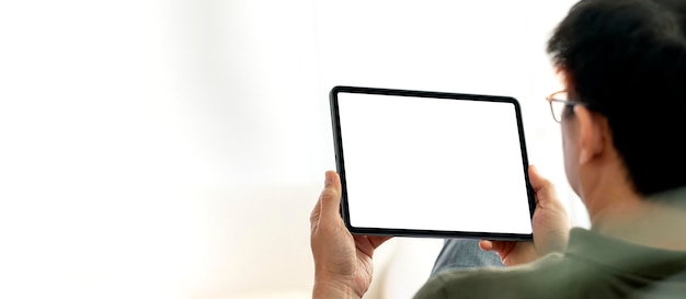 Man using digital tablet sitting at home mock up blank screen for product display