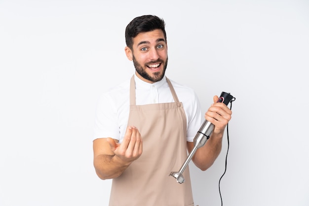 Man using hand blender isolated on white inviting to come