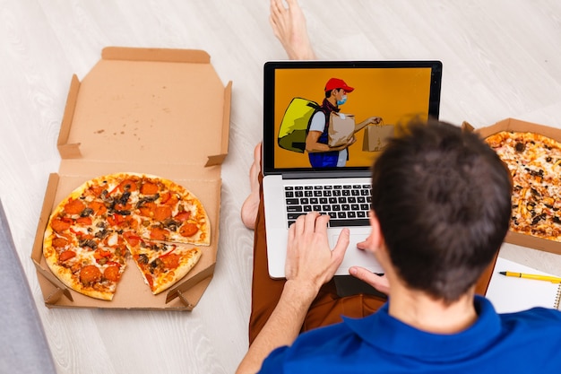 Photo man using laptop for online food order during quarantine, closeup. delivery service