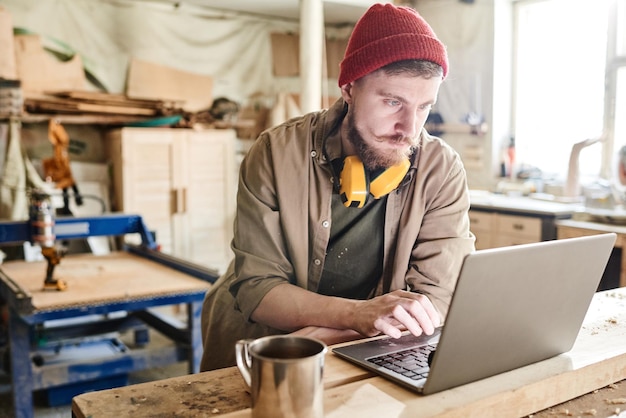 Man Using Laptop In Workshop