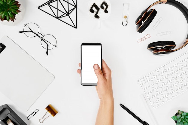 Man using phone over creative workspace mockup