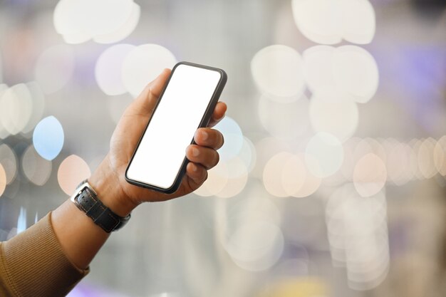 Man using smart phone over blurred bright background 