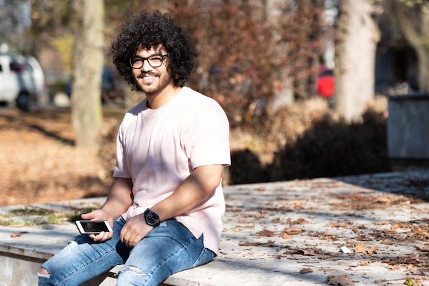 Man Using Smart Phone in a Fall Park