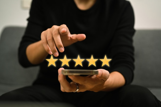 Photo man using smart phone and giving positive review  satisfaction surveys, giving a five star rating.