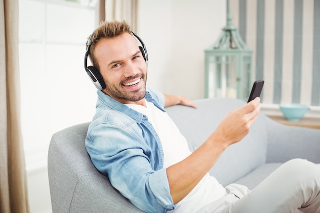 Man using a smart phone while listening to music 