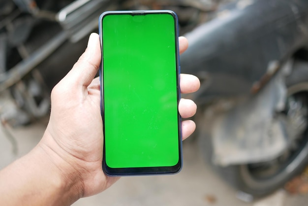 Man using smart phone with green screen for car service