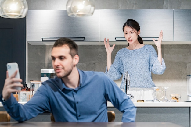 A man using smartphone and an angry woman