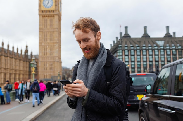 Man using smartphone on background of London Big Ben tower