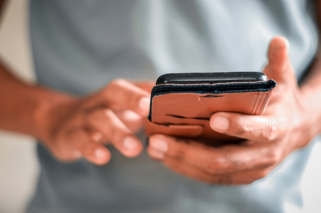 Man using smartphone on gray background.