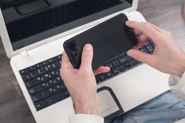 Man using smartphone at home.