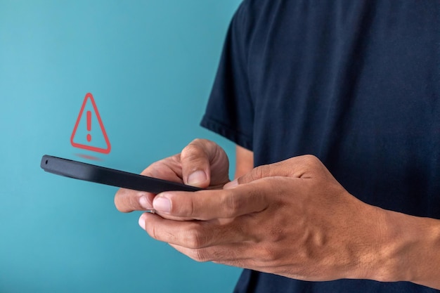 Photo man using a smartphone with red triangle caution warning sign for notification error restricted content or maintenance concept