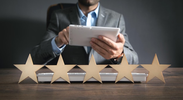 Man using white digital tablet Five star rating