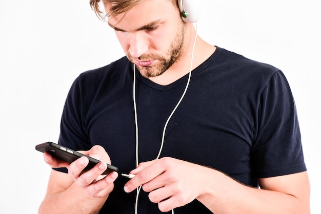 Man using wireless blue tooth headset relax playlist sexy muscular man listen music from playlist man relax in earphones isolated on white unshaven man relax with favorite song