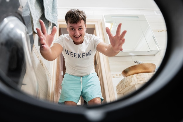 Man view from washing machine inside Male does laundry daily routine Come to papa