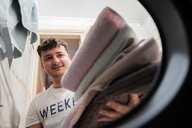 Man view from washing machine inside Male does laundry daily routine