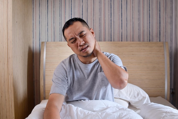 Man waking up in the morning and suffer for neck pain