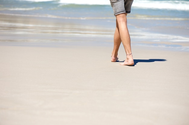 Man walking barefoot on vacation at the beach 