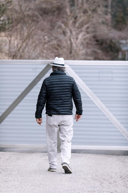 A man walking to his automatic gate coming home from work the security and safety of his own home