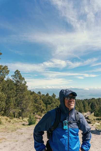 Man walking through a forest wearing a backpack