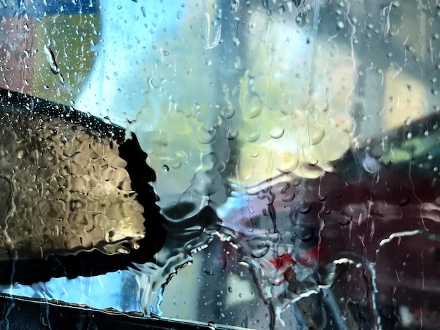 man washing car in car servis  centre ,window glass wet of washing water drops flowing