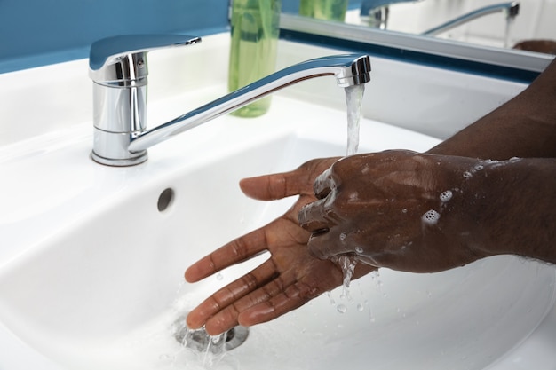 Man washing hands carefully with soap and sanitizer, close up. Prevention of pneumonia virus spreading, protection against coronavirus pandemia. Hygiene, sanitary, cleanliness, disinfection. Safety.