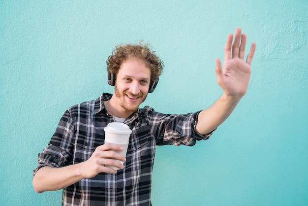 Man waving his hand and smile saying hello to someone.