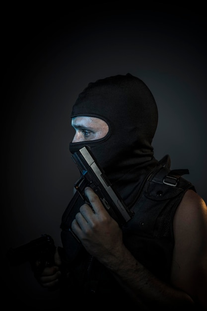 Man wearing balaclavas and bulletproof vest with firearms