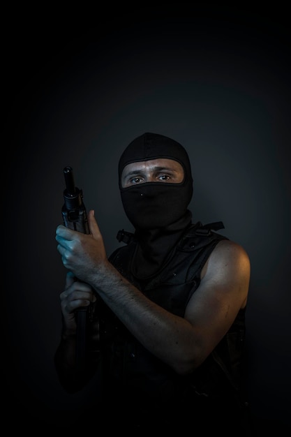 Man wearing balaclavas and bulletproof vest with firearms