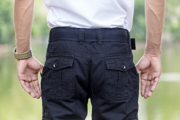 Man wearing black cargo pants and standing in the nature park