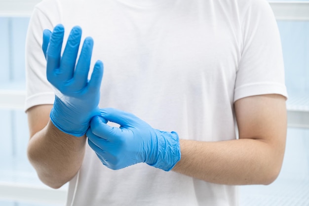 A man wearing blue nitrile gloves