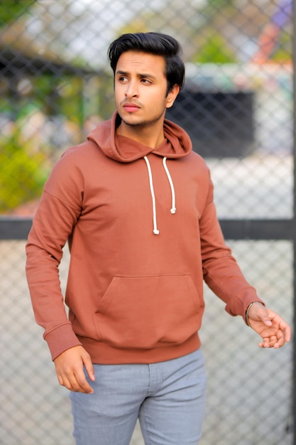 A man wearing a brown hoodie with the word love on it