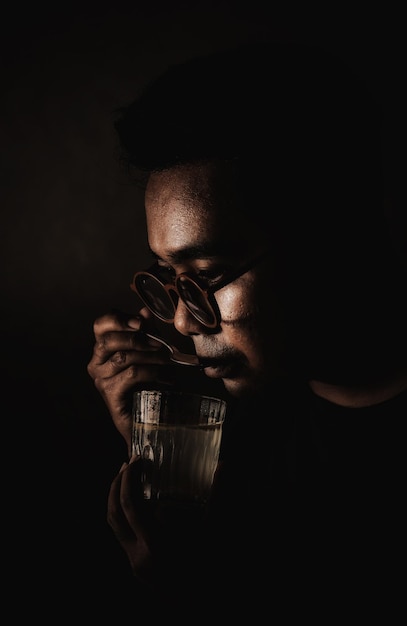 Man wearing glasses tasting a drink with a spoon