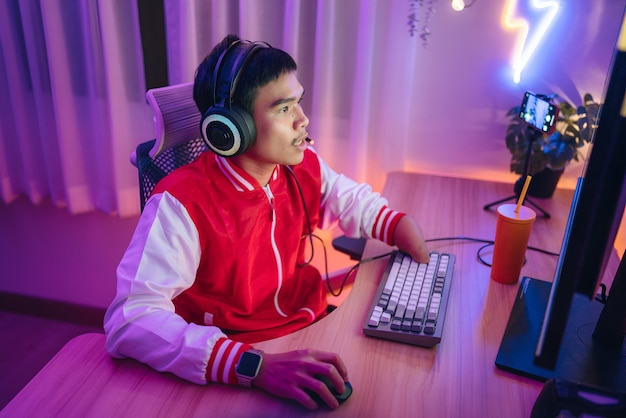 a man wearing headphones sits in front of a keyboard