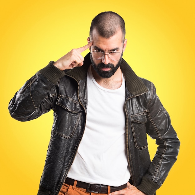 Man wearing a leather jacket thinking on colorful background