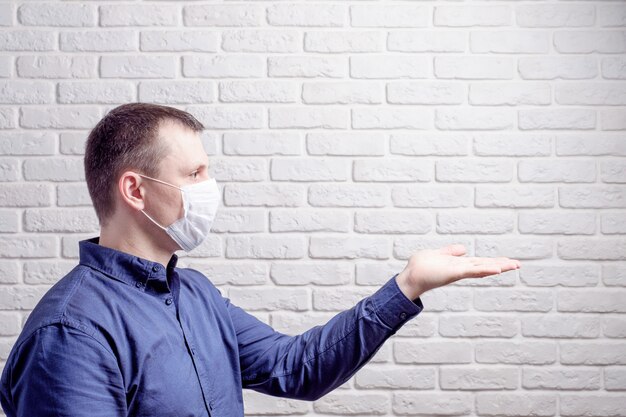 Man wearing a medical mask against the wall