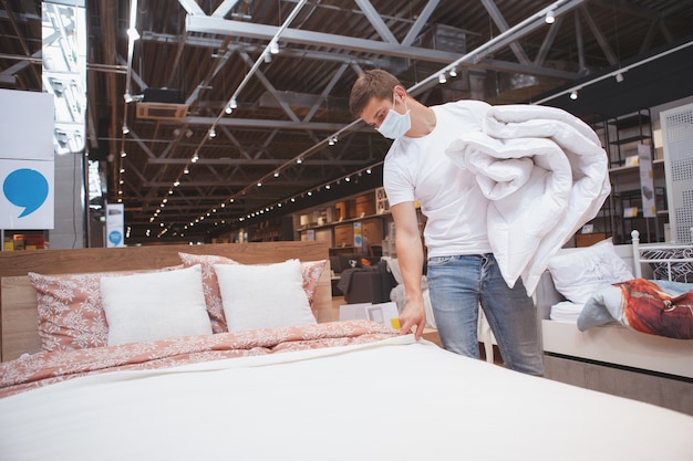 Man wearing medical mask shopping for furniture during coronavirus panemic