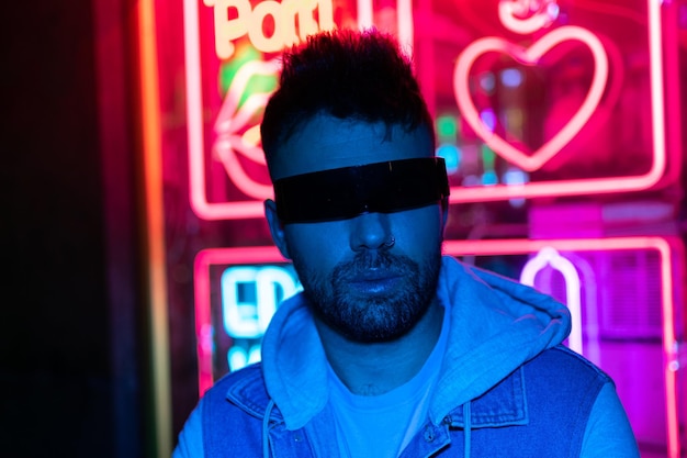 A man wearing a pair of black sunglasses stands in front of a neon sign that says pompeii.