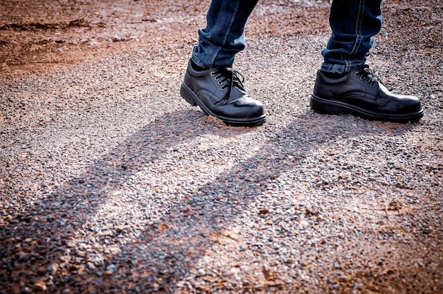 Man wearing safety shoes black color, standing on the ground