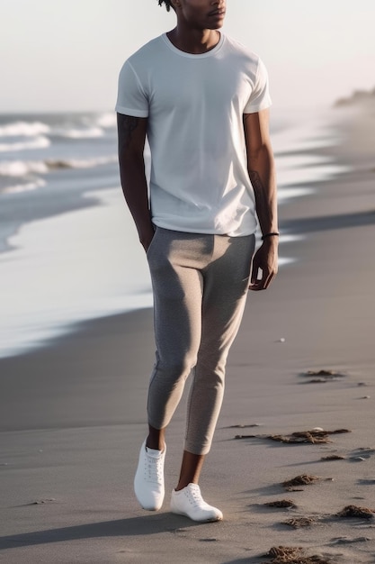 A man wearing a white polo shirt and a white t - shirt stands on a beach.