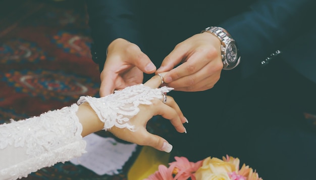 man wears wedding ring on the hand of the woman