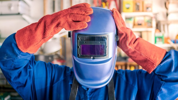 A man welder putting helmet for protect the eyes Worker wearing special clothes