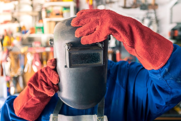 A man welder putting helmet for protect the eyes Worker wearing special clothes