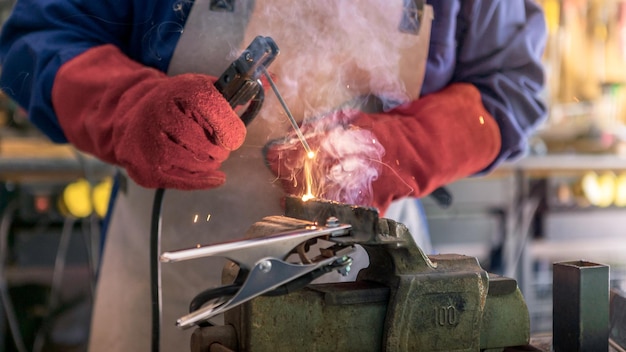 A man welder with safety helmet working with arc welding machine in the workshop