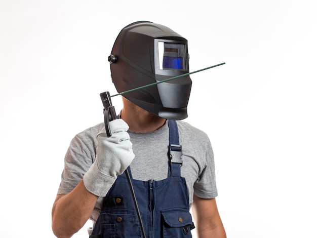 A man in a welding mask, robotic clothes and gloves, holding a wire with a welding electrode.