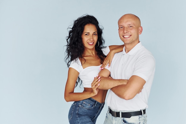 Man in white clothes and woman in jeans Cheerful couple is together indoors